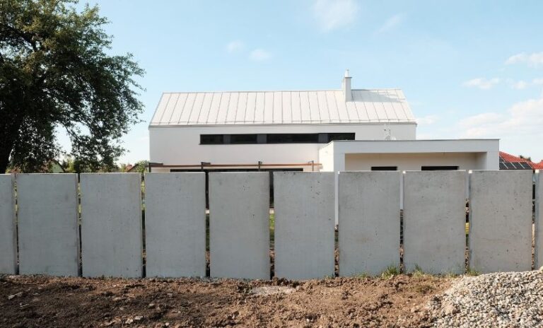 Ogrodzenie wykonane z betonowych pły prefabrykowanych.