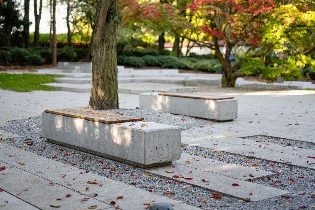 Dwie betonowe ławki w parku z betonowymi płytami