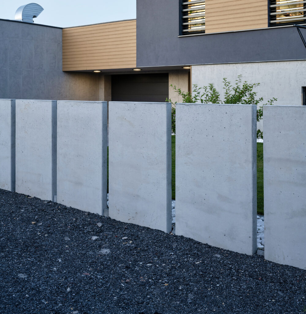 Ogrodzenie betonowe panelowe na tle nowoczesnego domu